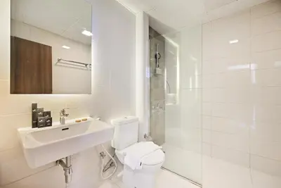 a white bathroom with a sink and a toilet at Modern 1BDR Apt With Balcony Pool Access And JVC in Dubai