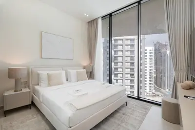 a bedroom with a white bed and a large window at Luxury 1BR - Binghatti Phantom - Amazing Amenities in Dubai