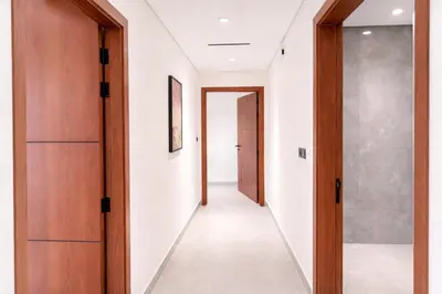 a hallway with wooden doors and white walls at Near World Trade Center Sleeps 5 Family Business Friendly in Dubai
