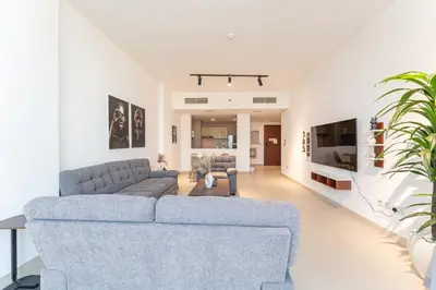 a living room with a blue couch and chairs at HAVN - 2 bed in Hilliana Tower, Jumeirah Burj View in Dubai