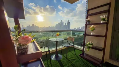 a balcony with a table and chairs and a view of a city at Luxury 2BR Haven with Panoramic Scenery - The Greens in Dubai