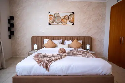 a bedroom with a large bed with white sheets at Luxury 2BR Haven with Panoramic Scenery - The Greens in Dubai