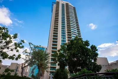 a tall building with a crane on top of it at Luxury 2BR Haven with Panoramic Scenery - The Greens in Dubai