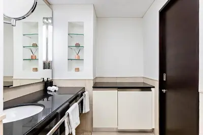 a white bathroom with a sink and a mirror at JW Marriott Marina Apartments in Dubai