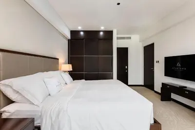 a bedroom with a white bed and a flat screen tv at JW Marriott Marina Apartments in Dubai