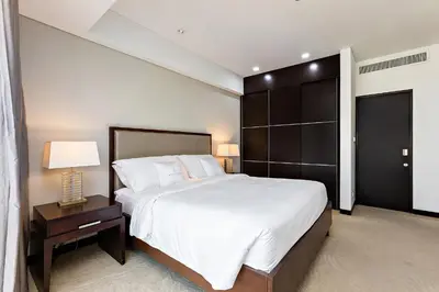 a large bedroom with a large bed and a night stand at JW Marriott Marina Apartments in Dubai