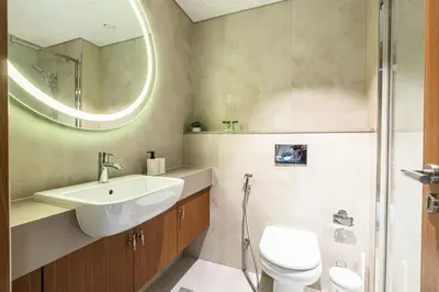 a bathroom with a sink and a toilet and a mirror at Exquisite studio apartment in Azizi Mirage in Dubai