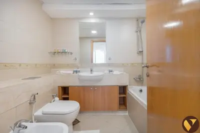 a bathroom with a toilet and a sink and a mirror at Vogue JLT Global Lake View Tower near Marina and JBR, Two Bedroom Apartment with Balcony and City view, Access to all Amenities in Dubai