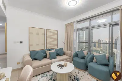a living room with a couch and chairs and a large window at Vogue JLT Global Lake View Tower near Marina and JBR, Two Bedroom Apartment with Balcony and City view, Access to all Amenities in Dubai