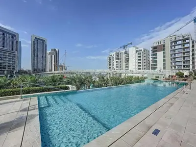 a large swimming pool in a city with tall buildings at Opulent Haven 2BDR w Sofa Bed Sleeps 6 In Vida-02 in Dubai