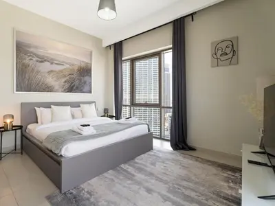 a bedroom with a large bed and a large window at Opulent Haven 2BDR w Sofa Bed Sleeps 6 In Vida-02 in Dubai