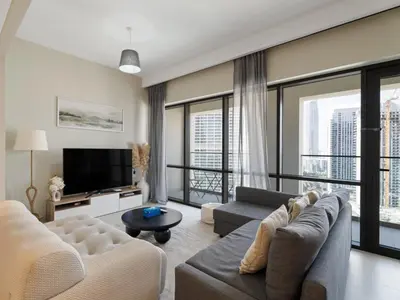 a living room with a couch and a tv at Opulent Haven 2BDR w Sofa Bed Sleeps 6 In Vida-02 in Dubai