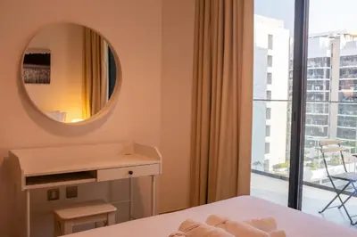 a bedroom with a mirror and a bed and a window at Large Beautiful One Bed Downtown Dubai in Dubai