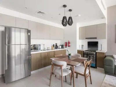 a kitchen with a table and chairs and a refrigerator at Elegant Suites 2BDR In Forte Downtown-32 in Dubai