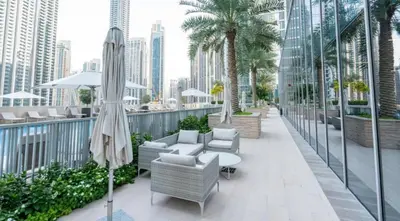 a balcony with chairs and a table and an umbrella at Elegant Suites 2BDR In Forte Downtown-32 in Dubai