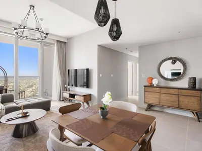 a living room with a table and chairs and a couch at Elegant Suites 2BDR In Forte Downtown-32 in Dubai