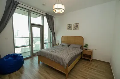 a bedroom with a bed and a large window at Skyline & Islands View 3BR Luxe Top Floor Noura Tower Business Bay in Dubai
