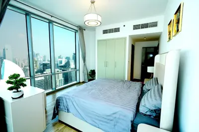 a bedroom with a bed and a large window at Skyline & Islands View 3BR Luxe Top Floor Noura Tower Business Bay in Dubai