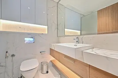 a bathroom with a sink and a toilet and a mirror at Bloomfields Grandeur 2BR in Azizi Riviera in Dubai