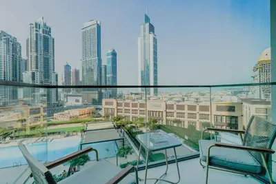 a balcony with chairs and a view of a city at TRPS - Burj Crown, Downtown - Skyline and Pool View, Furnished, Downtown in Dubai
