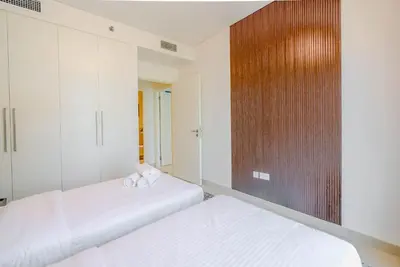 a bedroom with two beds and a wooden wall at TRPS - Burj Crown, Downtown - Skyline and Pool View, Furnished, Downtown in Dubai