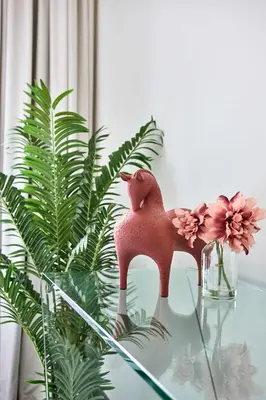 a glass table with a figurine on top of a plant at Frank Porter - The Crest Tower, Sobha Hartland in Dubai