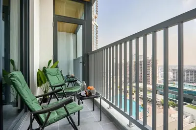 a balcony with chairs and a view of a city at Frank Porter - The Crest Tower, Sobha Hartland in Dubai