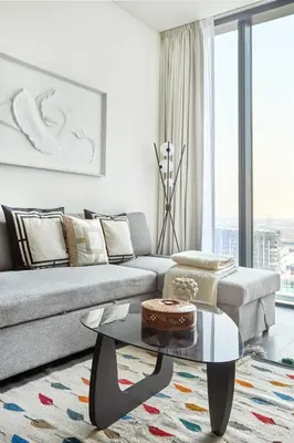 a living room with a couch and a table at Frank Porter - The Crest Tower, Sobha Hartland in Dubai