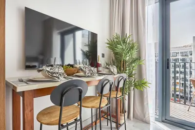 a kitchen with a table with chairs and a view of a city at Frank Porter - Azizi Beach Oasis in Dubai