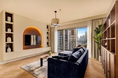 a living room with a couch and a large window at 4BR - Stunning Burj View - Dubai Mall Access in Dubai