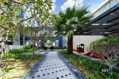 a courtyard with a palm tree in a building at The Cosmopolitan Spacious Studio in Dubai