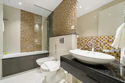 a bathroom with a sink and a toilet and a mirror at FIRST CLASS 2BR Vibrant Next to Dubai Mall in Dubai