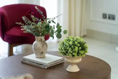 two vases on a table with flowers and a book at Burj Khalifa 2 BR apartment in the down town in Dubai