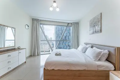 a bedroom with a large bed with a large window at HAVN - 3 bedroom in Park Towers, DIFC in Dubai