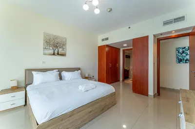 a bedroom with a large bed with white sheets at HAVN - 3 bedroom in Park Towers, DIFC in Dubai
