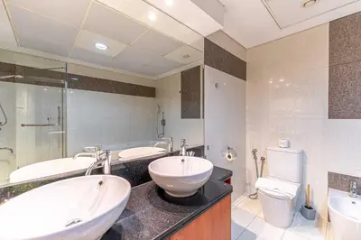 a bathroom with two sinks and a toilet at HAVN - 3 bedroom in Park Towers, DIFC in Dubai