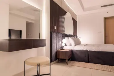 a bedroom with a bed and a table and a stool at Burj Khalifa View, Luxury 2B, Top Amenities and Equipment in Dubai