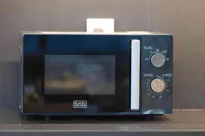 a black microwave oven sitting on top of a counter at Mahogany 25 - 2BR 10 Guests - Walk to Dubai Mall in Dubai