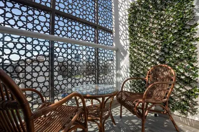 a patio with two chairs and a table and a wall at Stylish Studio in JVC with Pool and Gym Access in Dubai