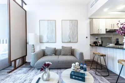 a living room with a couch and a table at Stylish Studio in JVC with Pool and Gym Access in Dubai