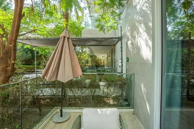 an umbrella sitting on a porch next to a window at Serene Studio in Al Barari Near Dubai Hills Mall in Dubai