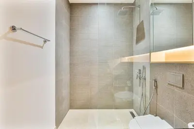 a bathroom with a toilet and a glass shower at Serene Studio in Al Barari Near Dubai Hills Mall in Dubai