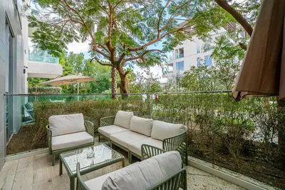 a patio with chairs and tables and a tree at Serene Studio in Al Barari Near Dubai Hills Mall in Dubai