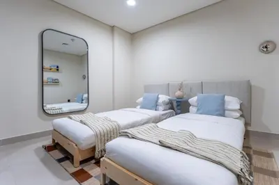 two beds in a room with a mirror at GuestReady | New 1BR with Maid’s Room | Spacious in Dubai