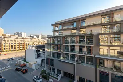 an apartment building in a city with a parking lot at GuestReady | New 1BR with Maid’s Room | Spacious in Dubai
