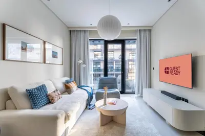 a living room with a couch and a table at GuestReady | New 1BR with Maid’s Room | Spacious in Dubai