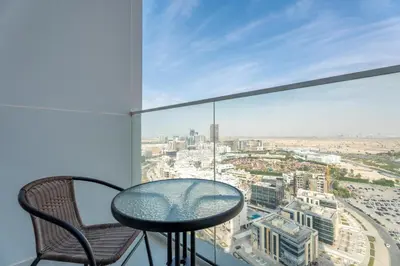 a glass table and chairs in a room with a view at GuestReady - Studio Suite l Community Jacuzzi in Dubai