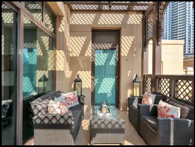 a porch with two couches and a coffee table at Skyline Souk 1 & 2 Bedroom Apartments I Burj Khalifa Views I Private Terrace I Gym, Pool, Parking & Wi-Fi in Dubai