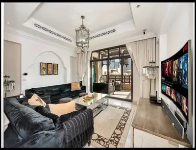 a living room with a black leather couch and a tv at Skyline Souk 1 & 2 Bedroom Apartments I Burj Khalifa Views I Private Terrace I Gym, Pool, Parking & Wi-Fi in Dubai
