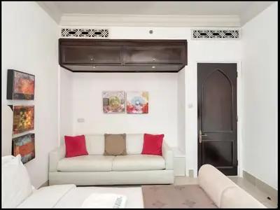 a living room with a white couch and red pillows at Skyline Souk 1 & 2 Bedroom Apartments I Burj Khalifa Views I Private Terrace I Gym, Pool, Parking & Wi-Fi in Dubai